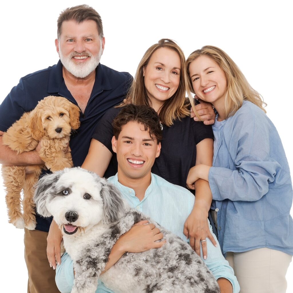 The Kaufman family and their two doodle puppies.